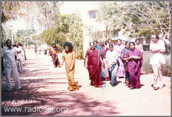 sathya sai baba walking towards the girls hostel, anantapur campus