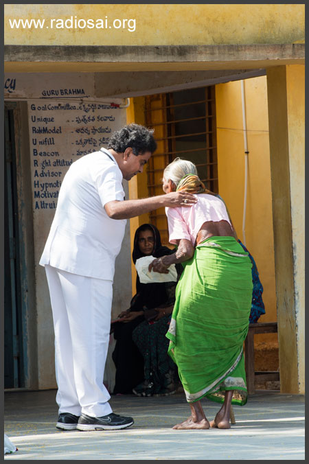 Dr. Narashimhan helping elderly woman patient